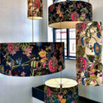 A cluster of multi coloured drum lampshades in a stairwell