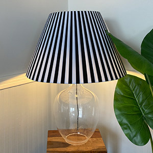 A black and white striped pleated empire on glass table lamp