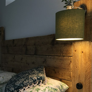 Green Oval An earthy green oval lampshade on a bedside wall light