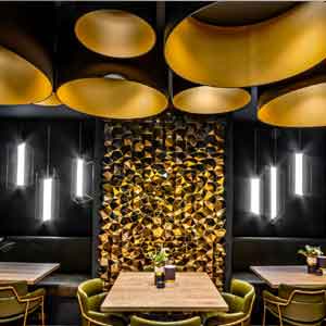 Clusters of black drum shades with gold linings in a restaurant setting