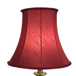 A traditional bell shaped standard lampshade in ruby faux silk