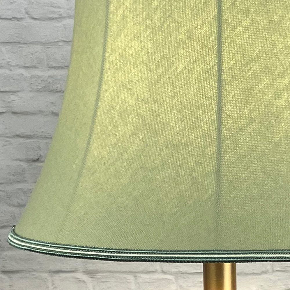 Close up image of a Traditional Green Brushed Cotton Lampshade with a two tone green and oyster Trim, lit up for floor lamp