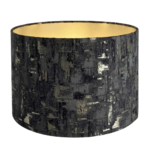 A black and charcoal drum lampshade with gold lining