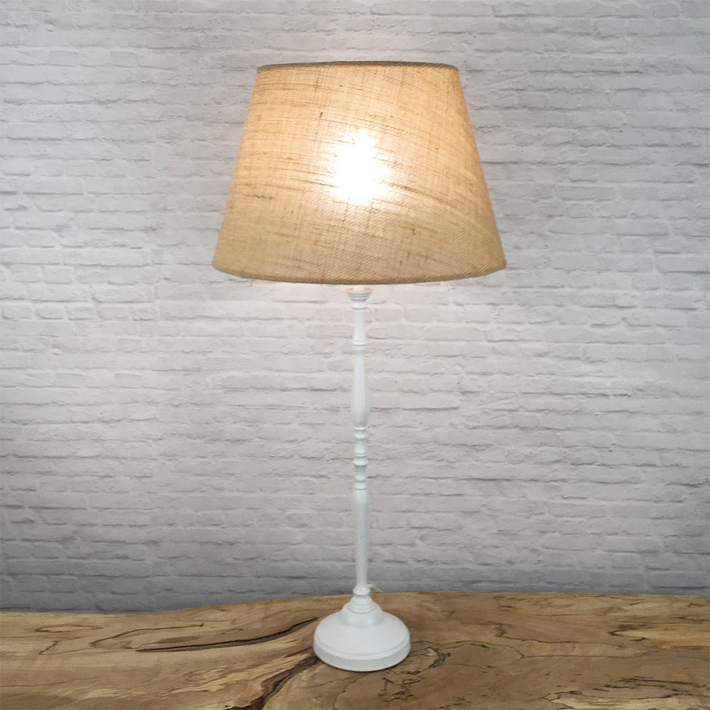 Natural hessian lampshade lit showing warm glow on a table lamp