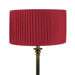 A burgundy coloured pleated drum lampshade on table lamp