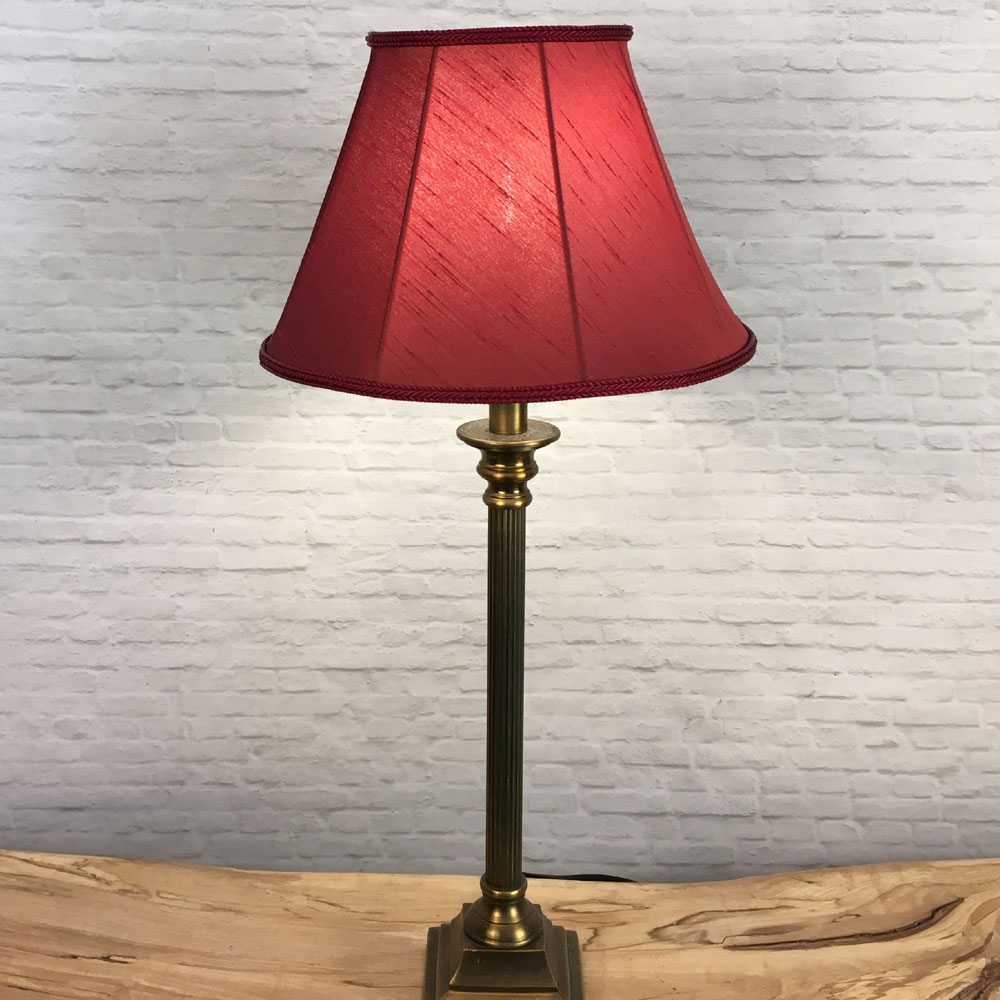 A Traditional table lamp showing our straight sided Empire lampshade in Ruby faux silk with a Ruby Faux Silk. Shown switched on. Suitable for all table, floor and standard lampshades