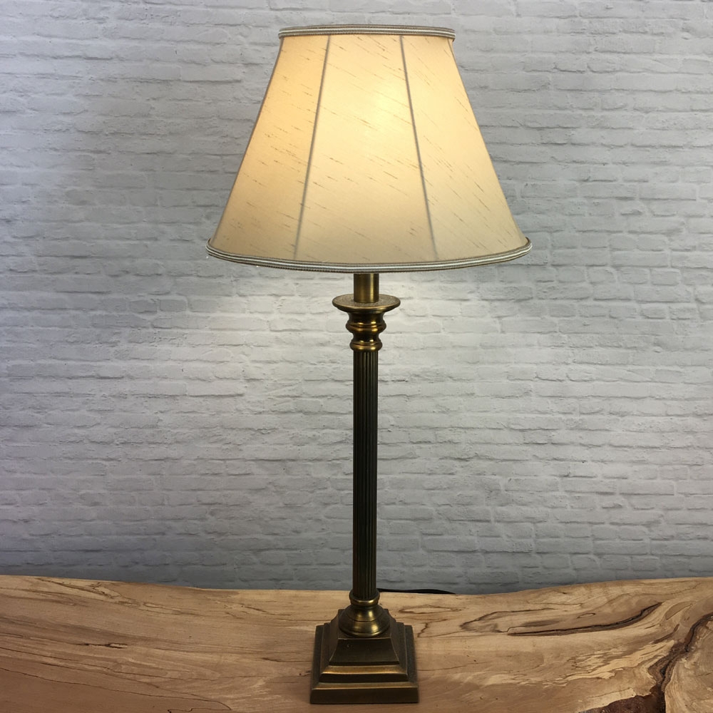 A Traditional table lamp showing our straight sided Empire lampshade in Fawn faux silk with a two toned fawn and oyster trim. Shown switched on. Suitable for all table, floor and standard lampshades