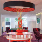 An extra large thin drum shade in black with red lining in situ at Virgin Bank