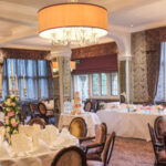 Decorative chandeliers surrounded with a beige drum lampshade.