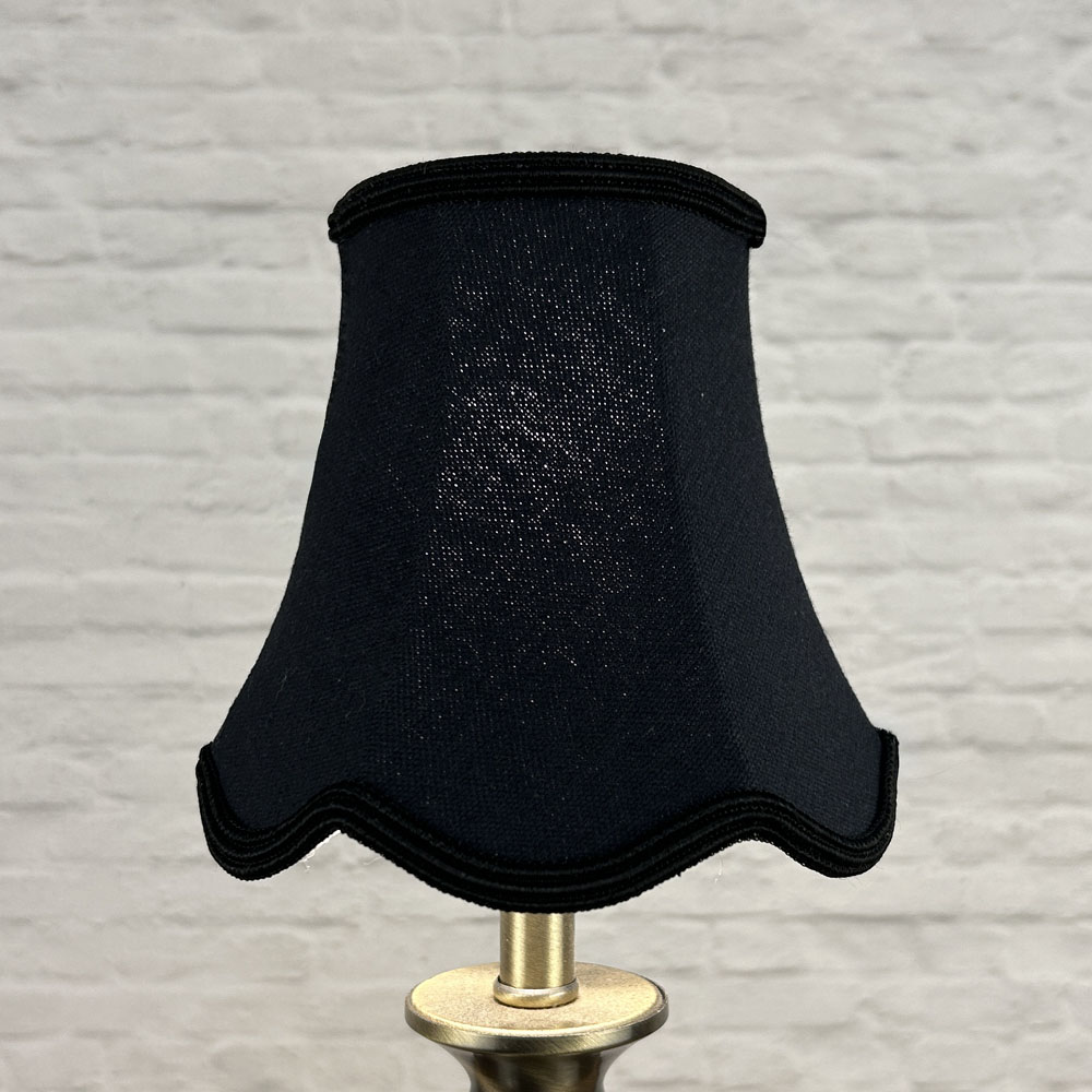 Black scalloped chandelier shade in brushed cotton lit showing warm glow and black soutache trim