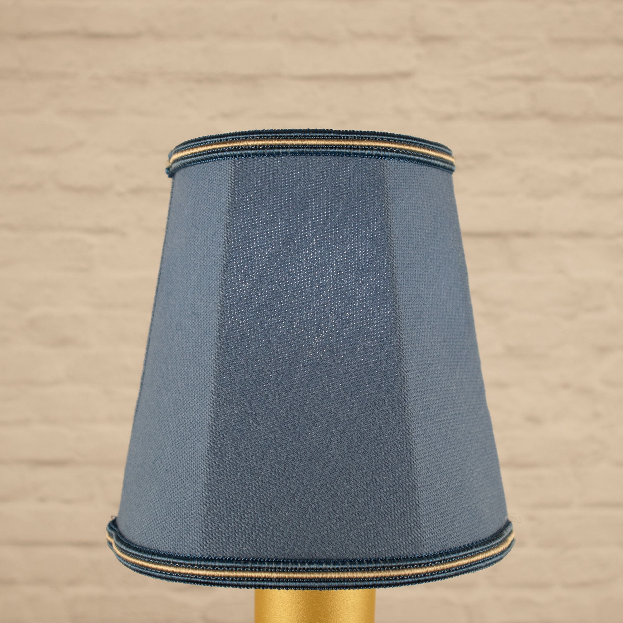 Lit blue empire brushed cotton candle shade with blue and fawn soutache trim