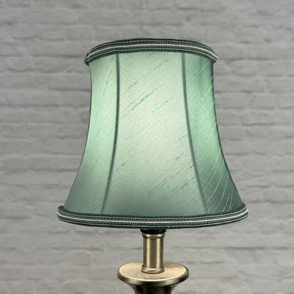 Green bowed chandelier shade in faux silk lit showing rich colour