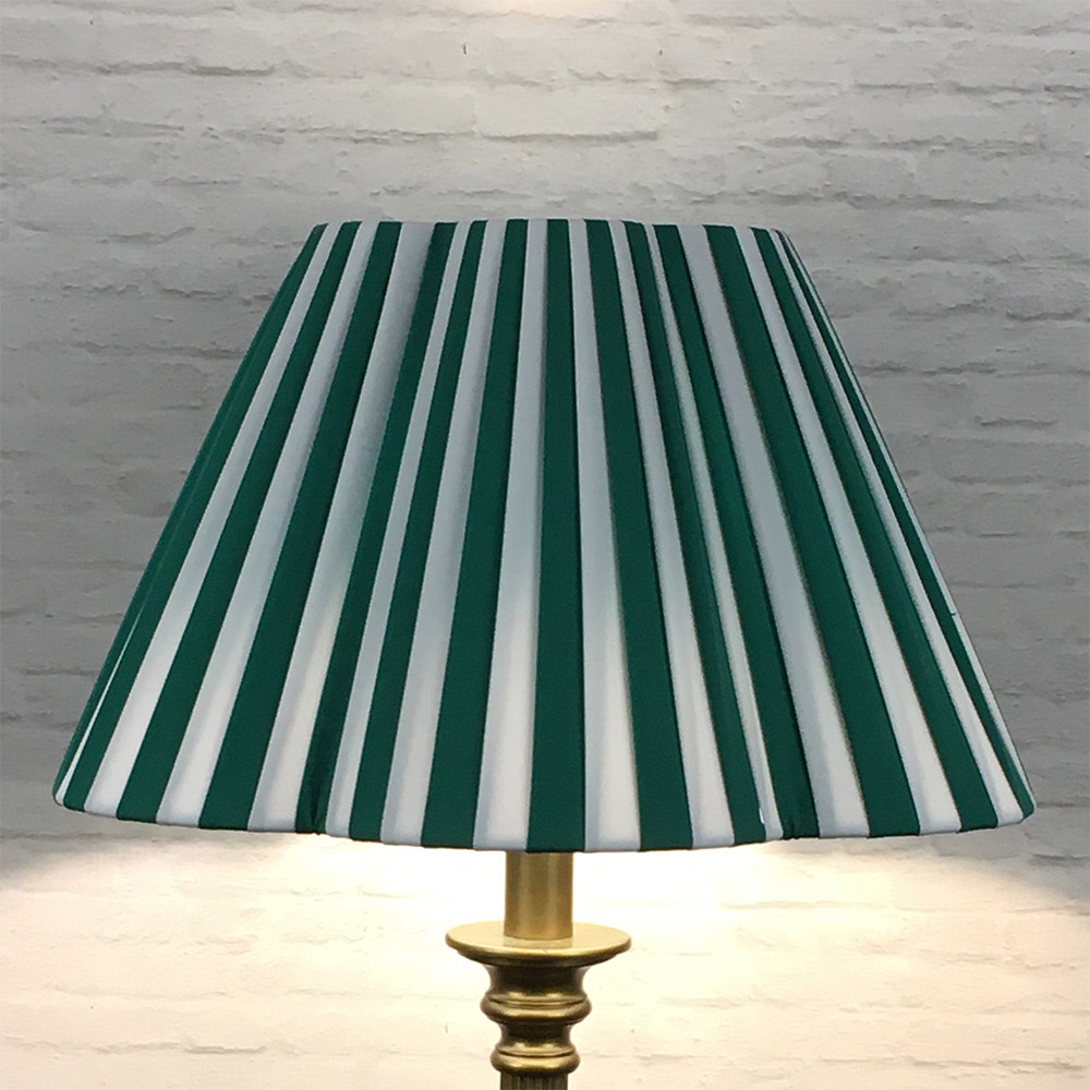 Green and white striped daisy pleated lampshade on a freestanding floor lamp base