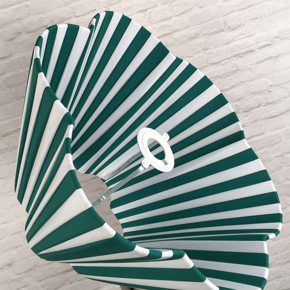 Green and white striped daisy pleated lampshade styled in an interior