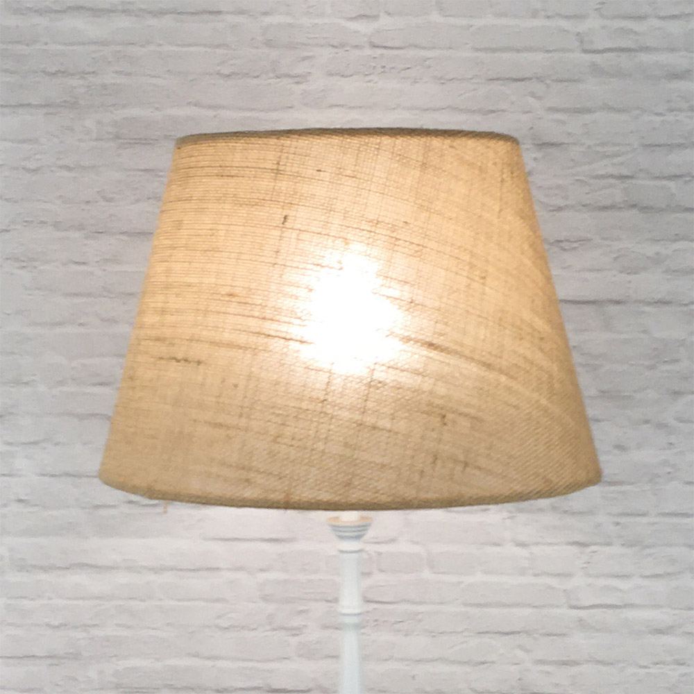 Natural hessian lampshade on floor lamp lit