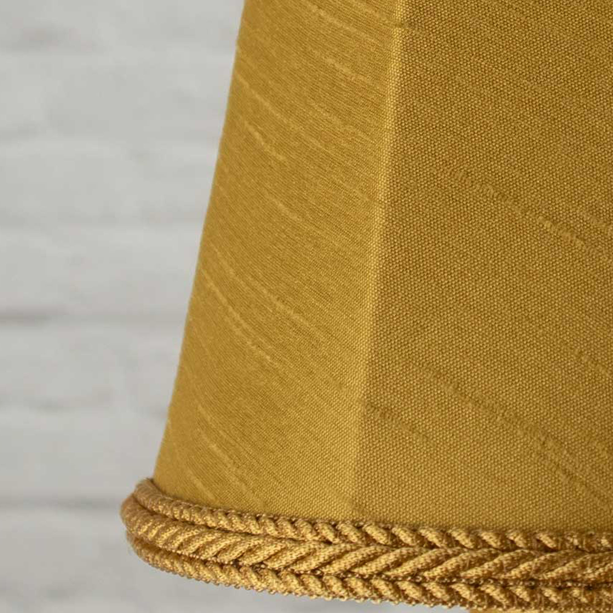 Close-up of old gold faux silk fabric showing dupion slub texture on empire chandelier shade