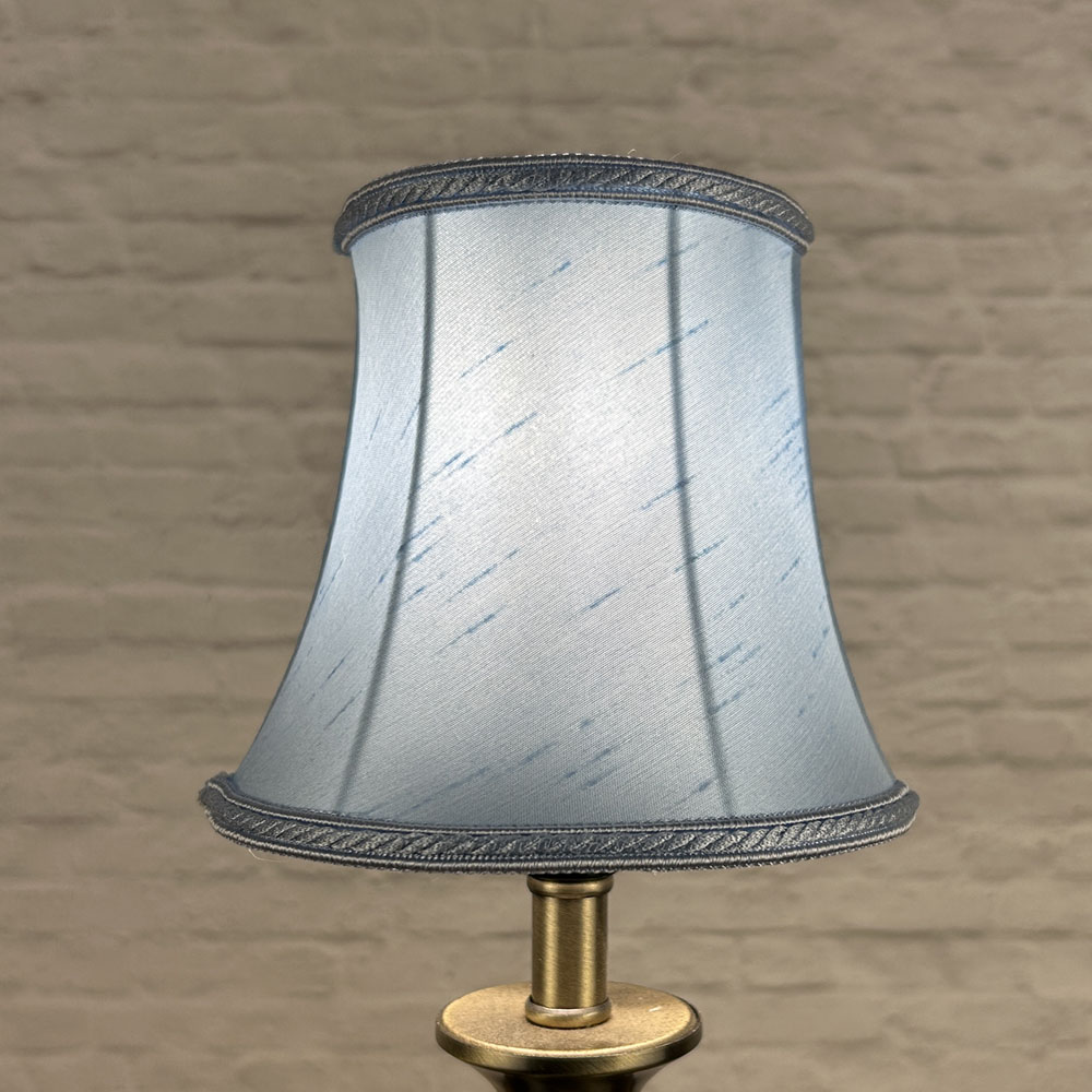 Pale blue bowed chandelier shade in faux silk lit showing soft tone