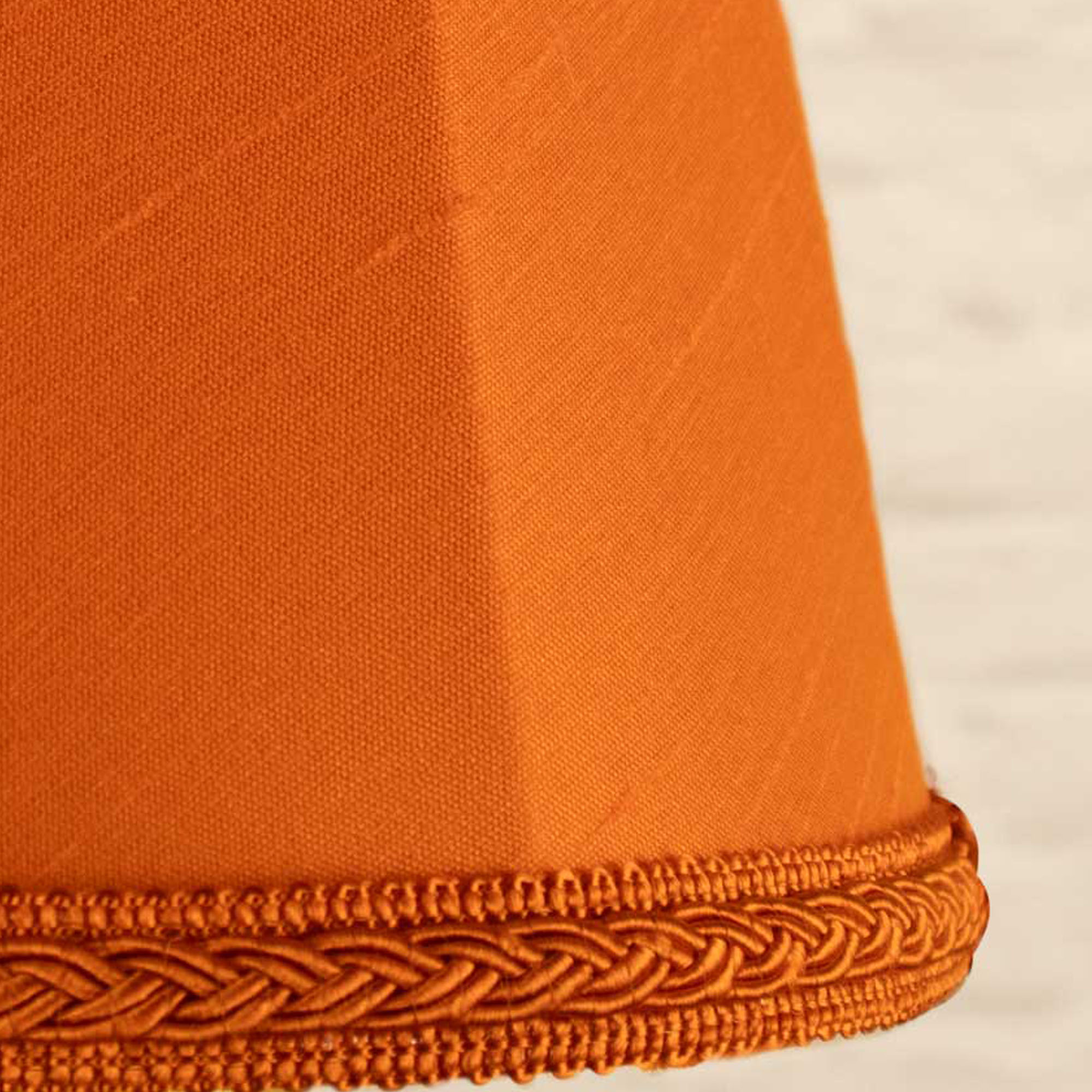 Close-up of pumpkin faux silk fabric showing dupion slub texture on empire chandelier shade