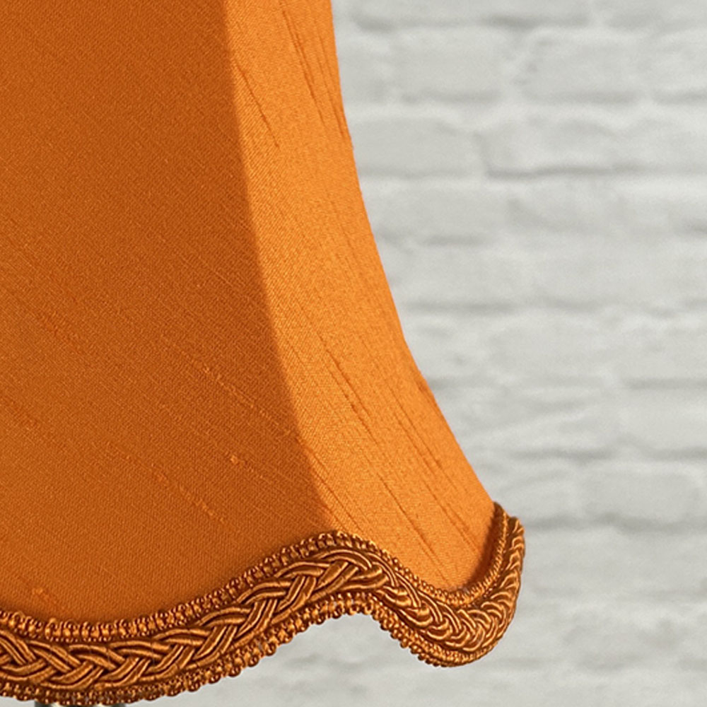 Close-up of pumpkin orange faux silk scalloped chandelier shade with plait trim