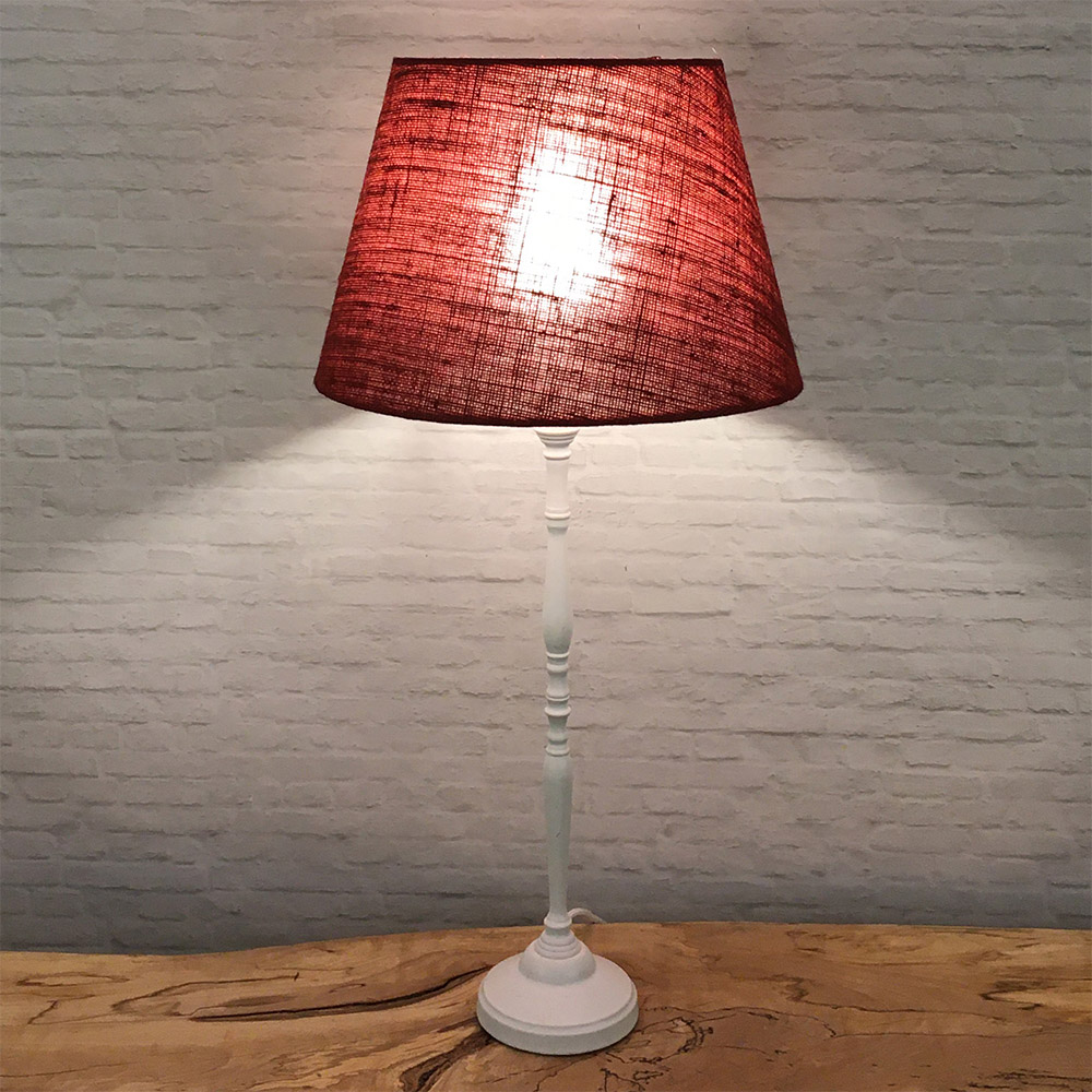 Red hessian tapered drum lampshade in low light showing woven texture