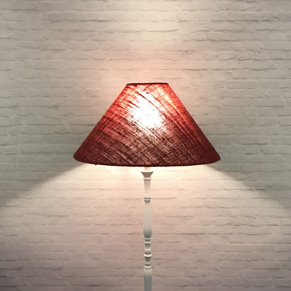 Red burlap coolie table lamp illuminated in low light