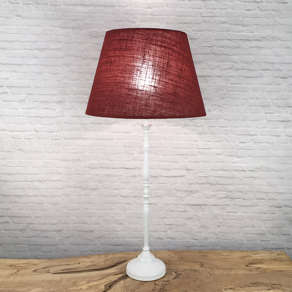 Red hessian lampshade lit on a table lamp