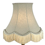 A retro scalloped lampshade in cream with matching fringe
