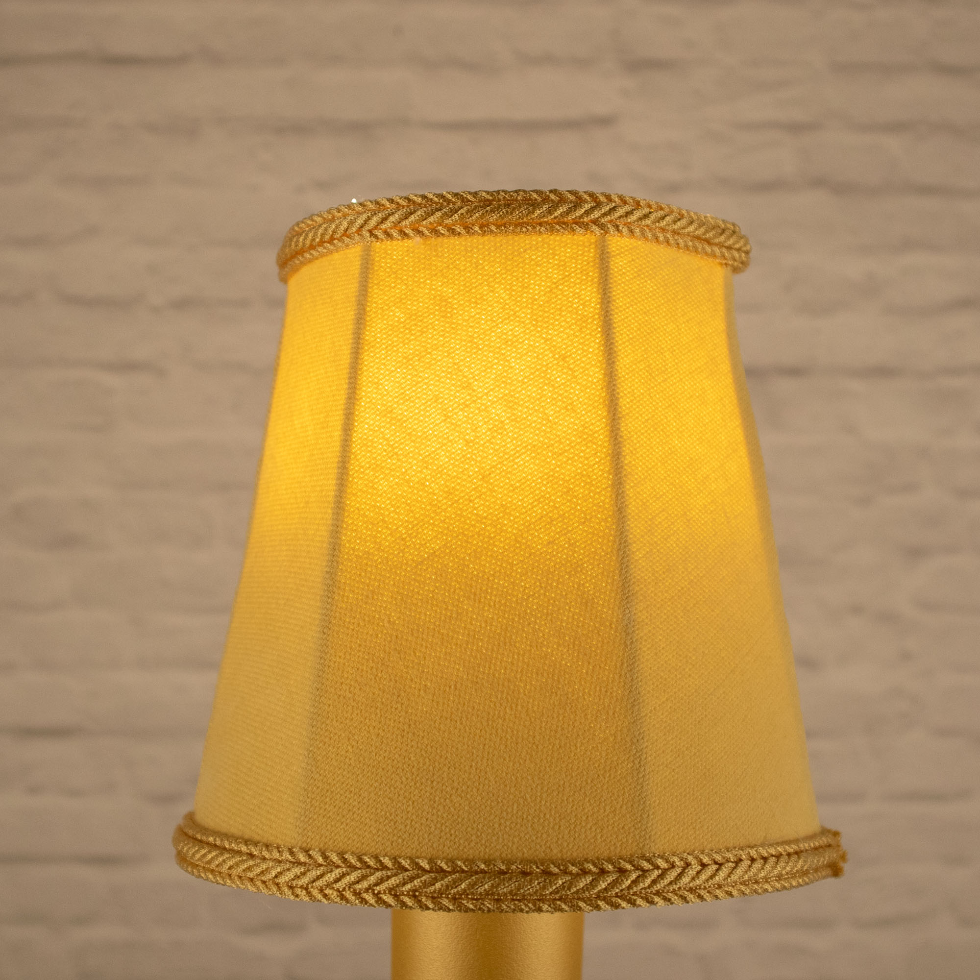 Lit soft gold empire brushed cotton candle shade with matching rope trim