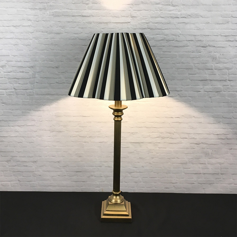 Tri-stripe daisy pleated lampshade shown on a table lamp base